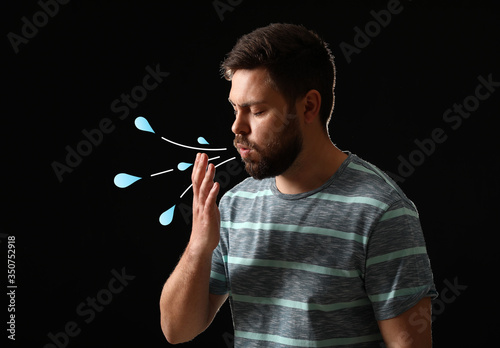 Coughing man on dark backgr...