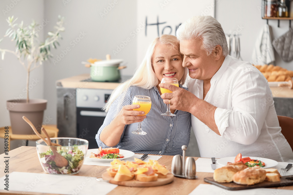 Happy elderly couple having breakfast at home