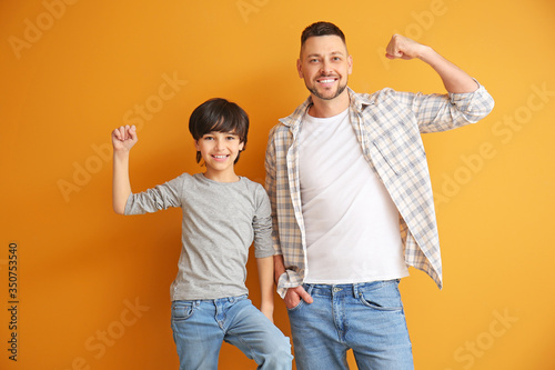 Father and little son on color background