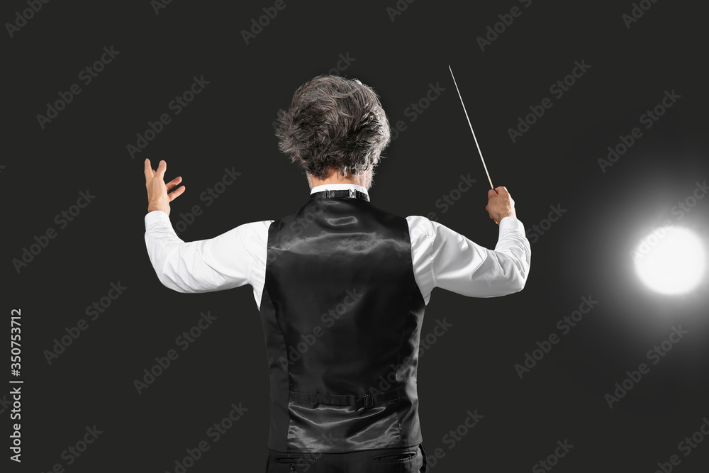 Senior male conductor on dark background Senior male conductor on dark background