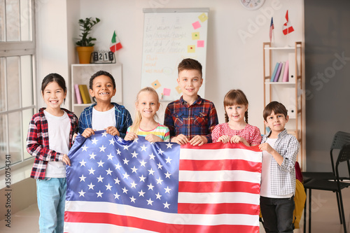 Obraz na plátně Little children with flag of USA at language school