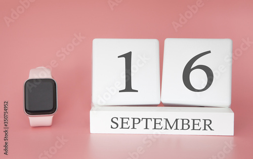 Modern Watch with cube calendar and date 16 september on pink background. Concept autumn time vacation.