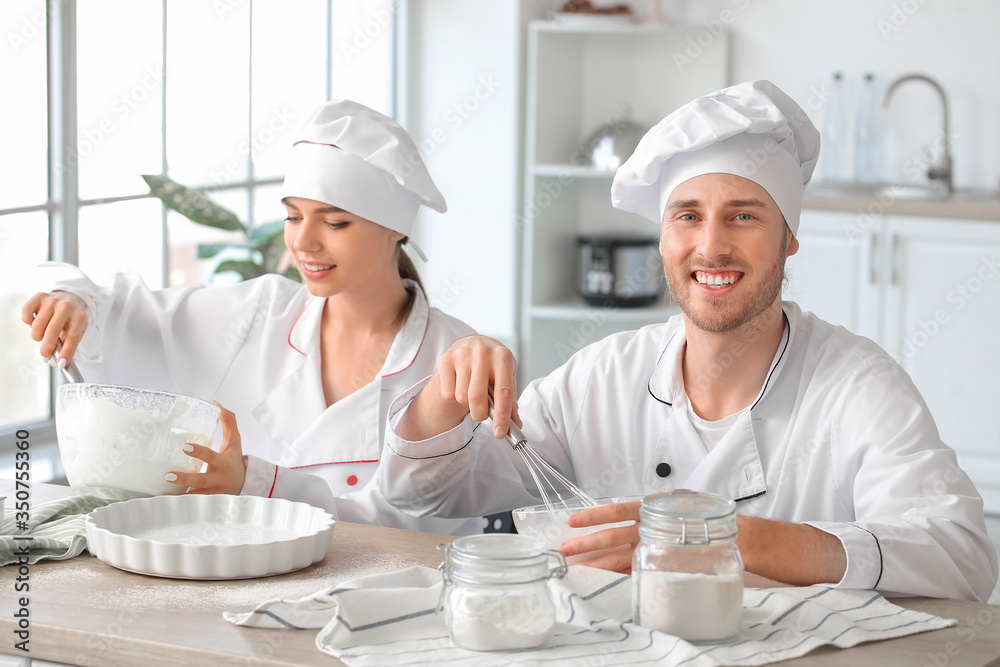 Young confectioners cooking tasty dessert in kitchen Young confectioners cooking tasty dessert in kitchen