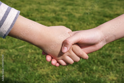 Children shaking hands　握手する子供 © Kana Design Image