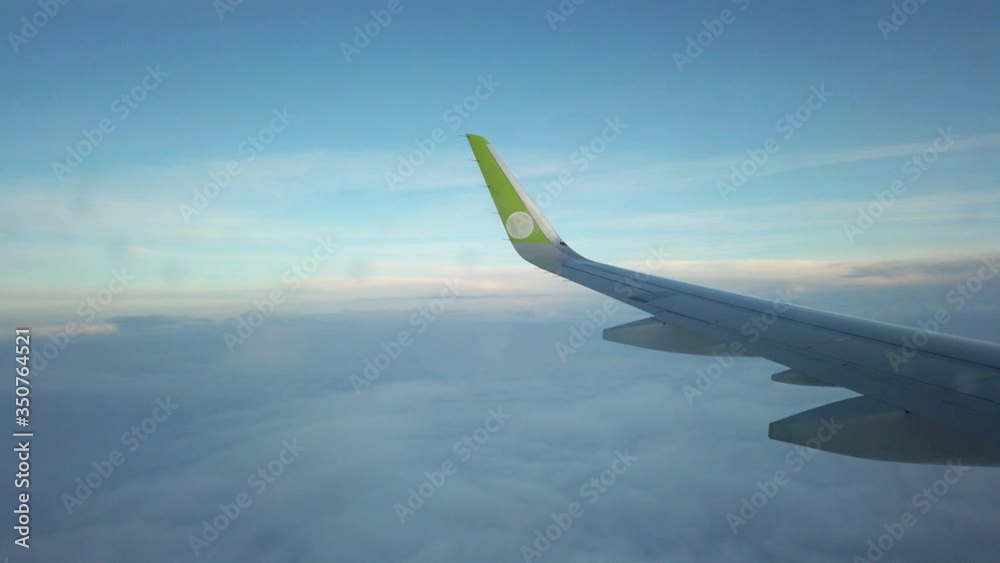 The plane is descending from a height, light cloudiness is visible below. The plane is descending from a height, light cloudiness is visible below.
