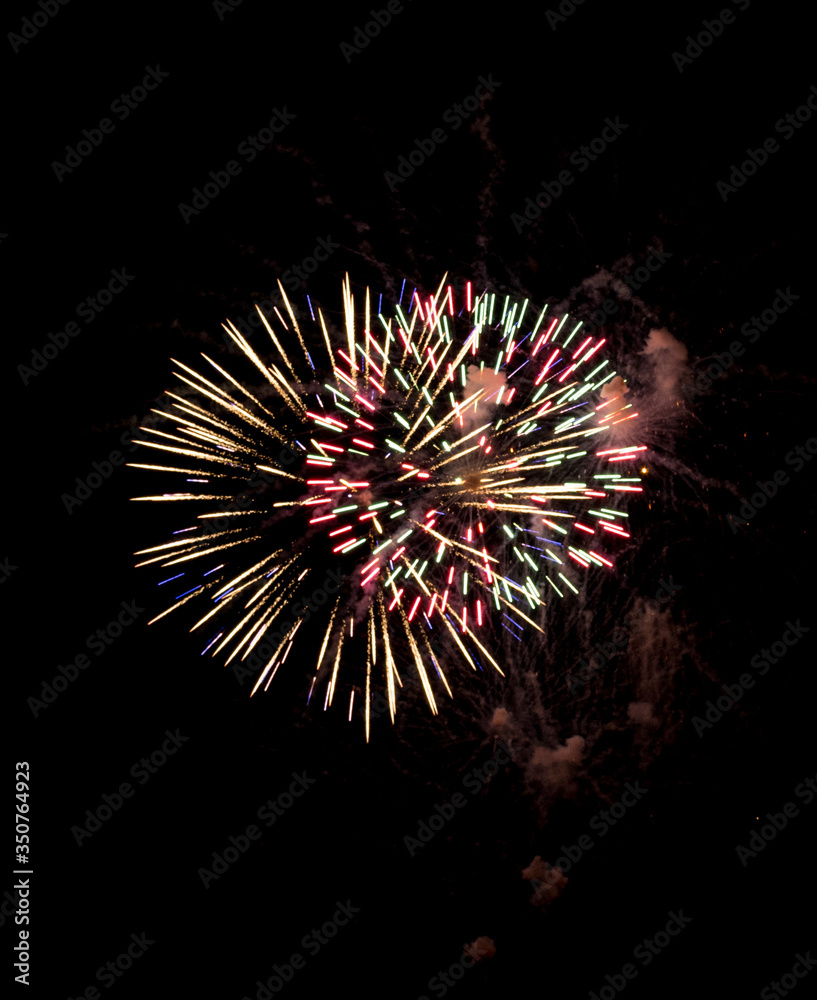 Fototapeta premium Explosive colorful fireworks display celebrating the fourth of July holiday leaving room for copy..