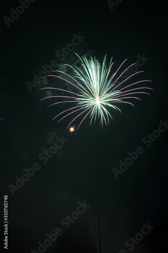 Explosive colorful fireworks display celebrating the fourth of July holiday leaving room for copy..