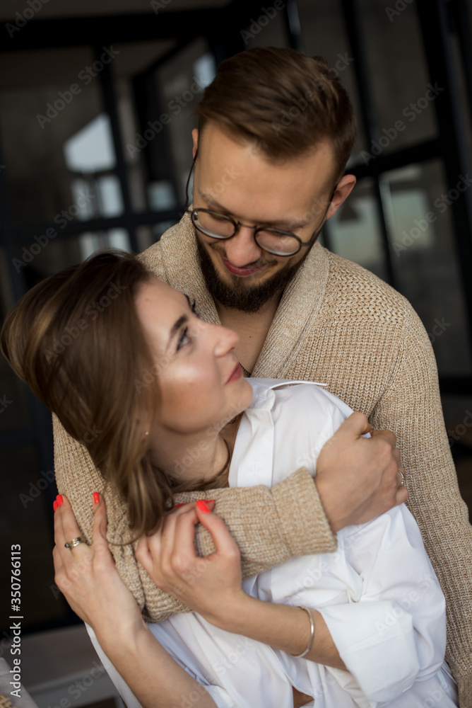 Beautiful young couple at home. Hugging, kissing and enjoying spending time together in the kitchen. Concept of good relations. Beautiful young couple at home. Hugging, kissing and enjoying spending time together in the kitchen. Concept of good relations.