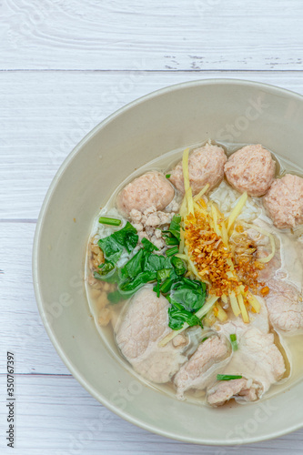 Thai Breakfast, Hot Thai rice soup with pork and meat on bowl with white wood background