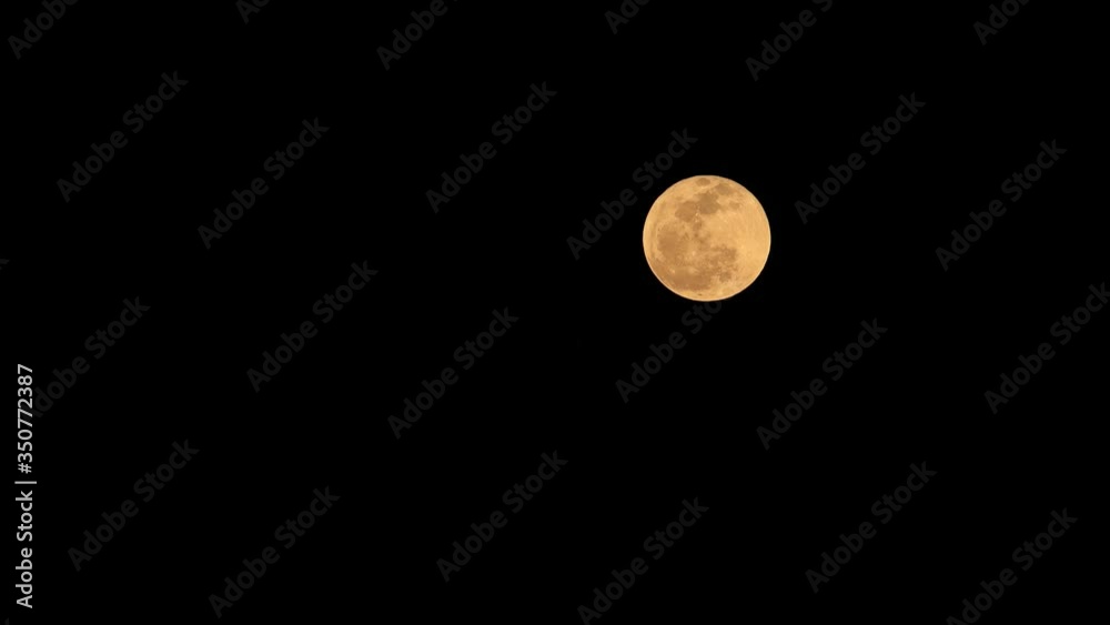 Timelapse of full moon rise with dark night sky with copy space Timelapse of full moon rise with dark night sky with copy space