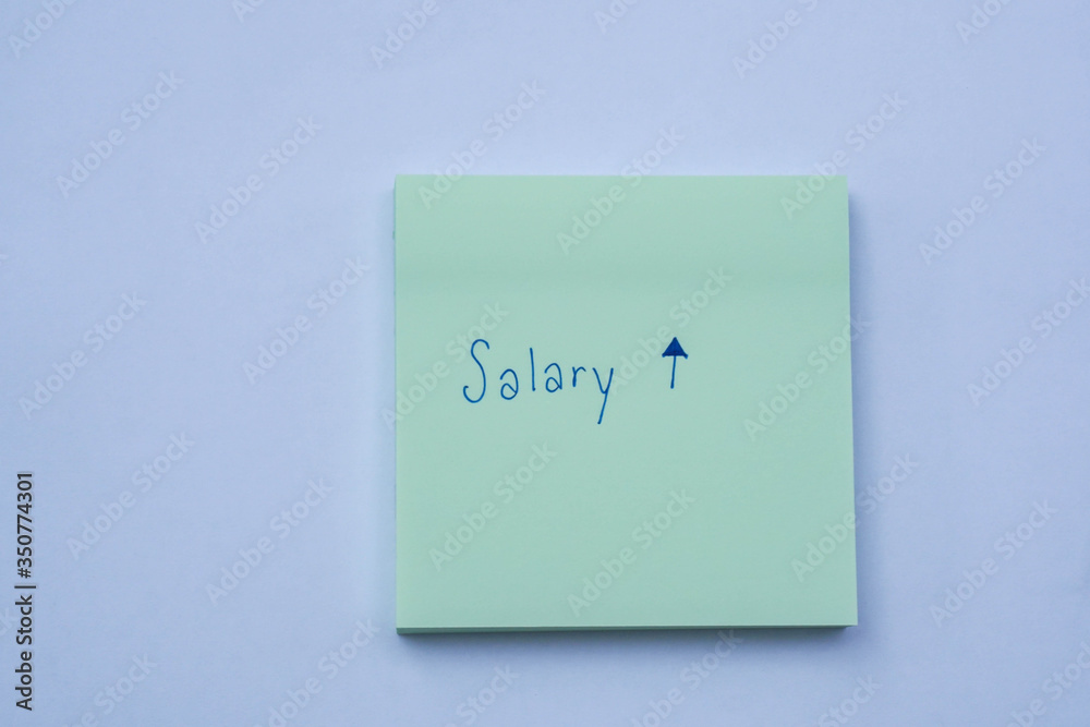 Business success concept sticky note with hand writing of salary increase and raise message Business success concept sticky note with hand writing of salary increase and raise message