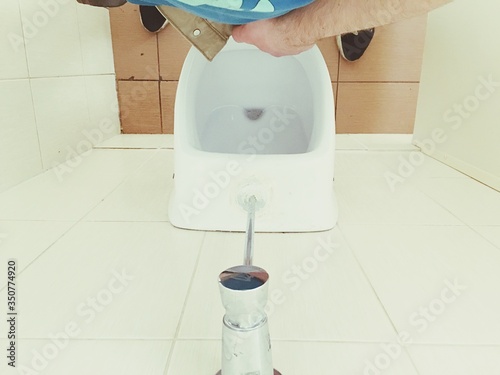 Fototapeta Low Section Of Man Urinating In Toilet
