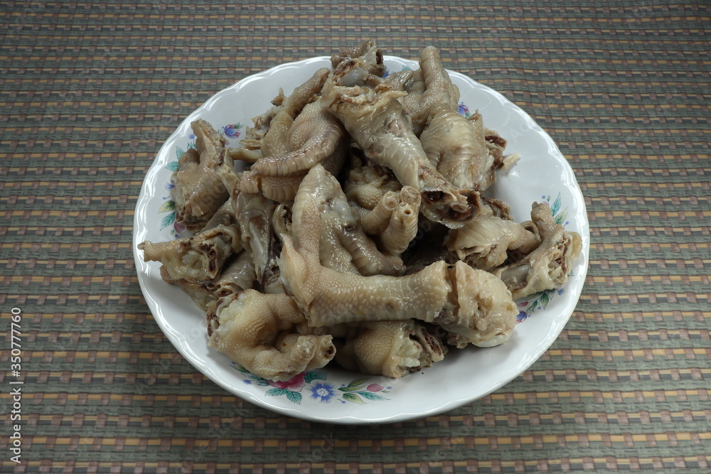 Pile of traditional Boiled or steamed chicken feet on the plate. Famous dim sum menu in Chinese restaurant. Local food in Asia. Pile of traditional Boiled or steamed chicken feet on the plate. Famous dim sum menu in Chinese restaurant. Local food in Asia.