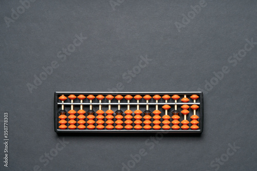 Soroban abacus on black background with copy space. Concept math education, mental mathematics, school arithmetic, calculating thinking