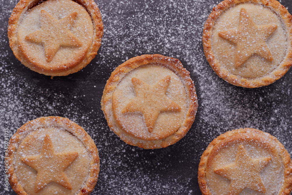 Flat lay image of some mince pies,which have been dusted with icing sugar.