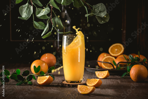 Fresh orange juice with fresh fruits on dark background