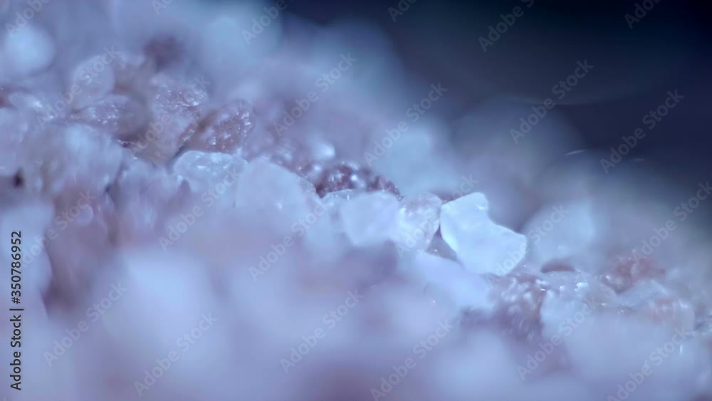 A hill of pink coarse salt rotates and shines in the light with its smooth edges. Macro. Closeup. Shallow depth of field A hill of pink coarse salt rotates and shines in the light with its smooth edges. Macro. Closeup. Shallow depth of field