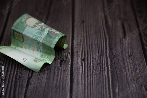 crumpled Ukrainian money on a dark background, twenty hryvnia