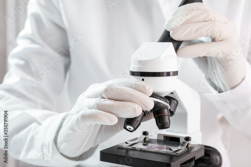 Scientist using microscope in laboratory  closeup