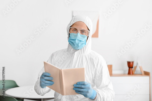 Man in biohazard suit readi...