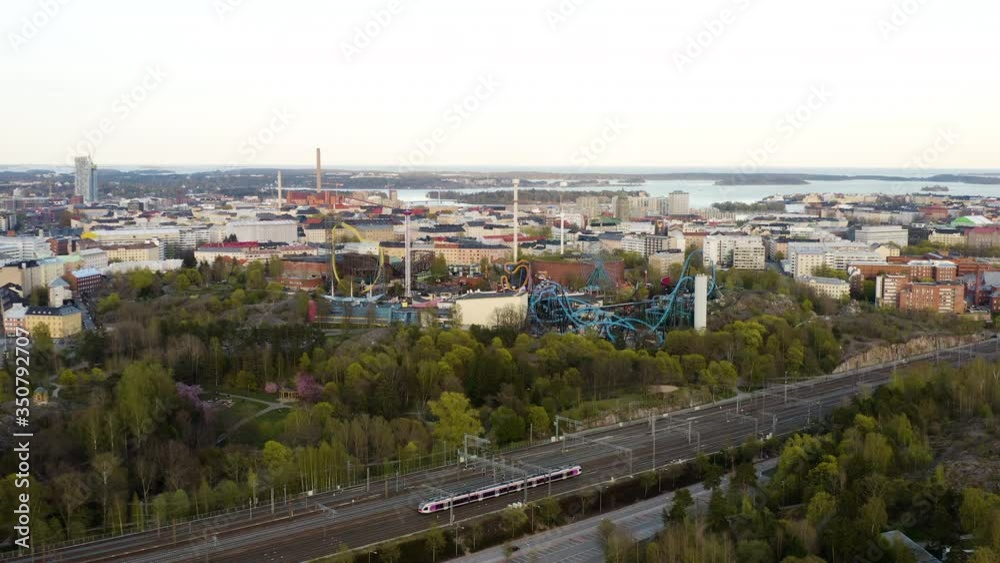 Aerial, drone shot, over a train, towards the Linnanmaki amusement park, sunny, spring day, in Helsinki, Finland
Aerial, drone shot, over a train, towards the Linnanmaki amusement park, sunny, spring day, in Helsinki, Finland