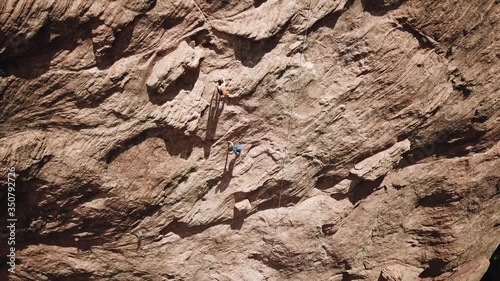 Two explorers find their way through rocky terrain in Utahs' Coyote Gulch as a drone rises into the air. photo