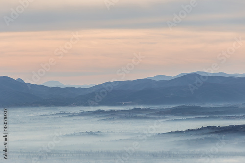 Fog filling a valley in Umbria (Italy) at dawn, with layers of mountains and hills