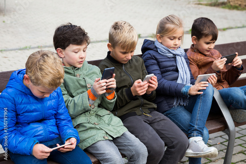Children on bench with phones