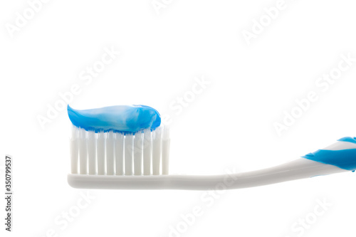 Toothpaste on toothbrushes on white background.