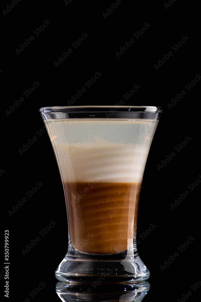 B52 coffee creamy alcohol cocktail in three layers in a shot glass on a black background B52 coffee creamy alcohol cocktail in three layers in a shot glass on a black background