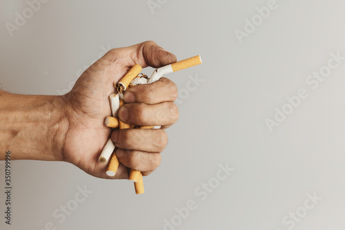 Hand clutching cigarette and crush for destroy.Cigarettes is addictive to be cancer.smoking reduction campaign in World No Tobacco Day.