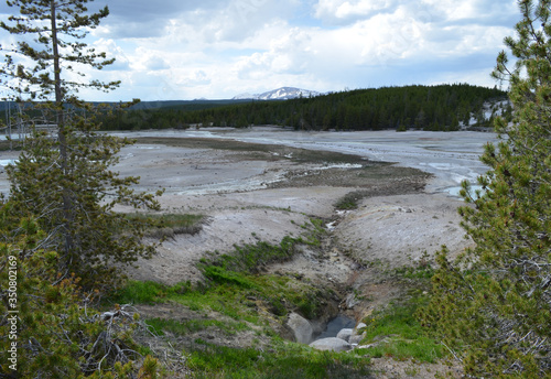 Late Spring in Yellowstone National Park: Basin Geyser in the Foreground of the Porcelain Basin Area in Norris Geyser Basin with Mount Holmes of the Gallatin Range in the Background