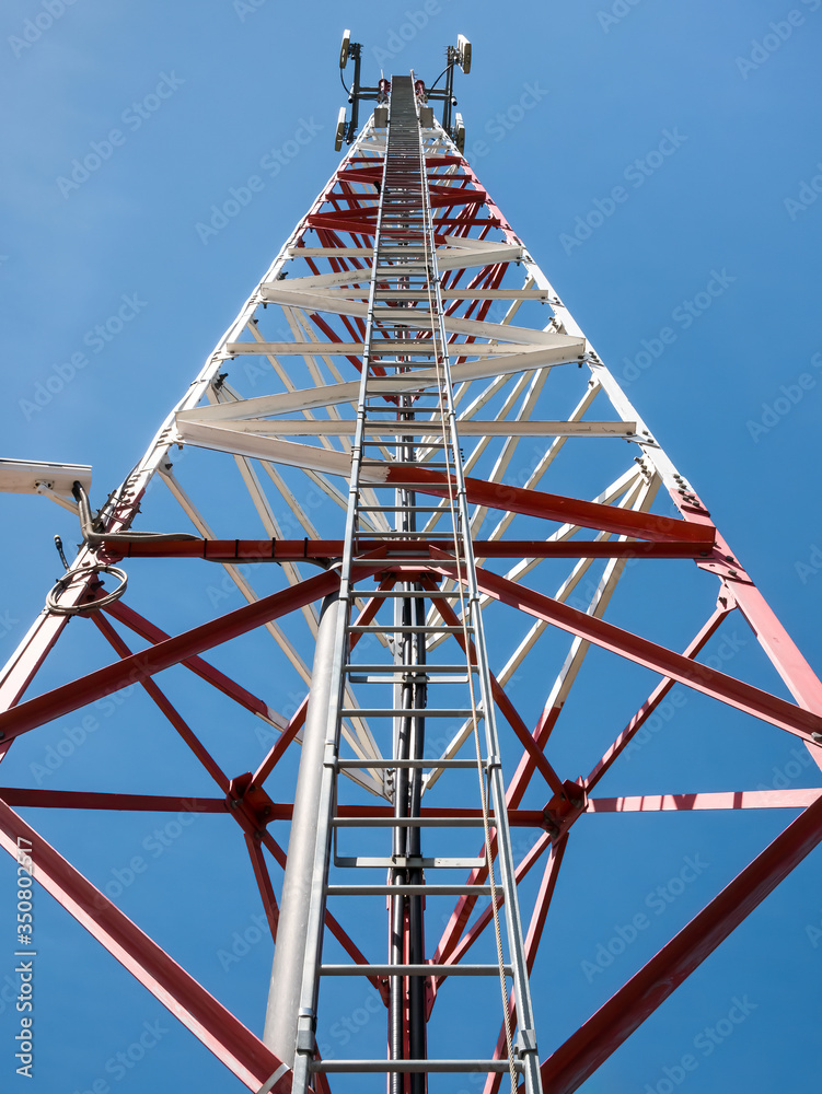 Ladder or steps on a transmission tower towards the bright blue sky.