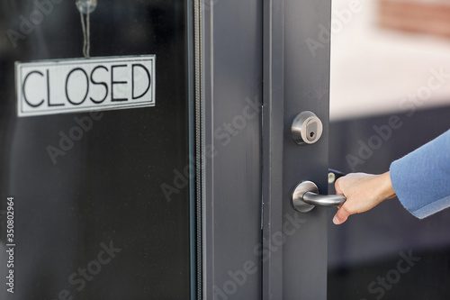 small business, pandemic and service concept - hand trying to open closed office door