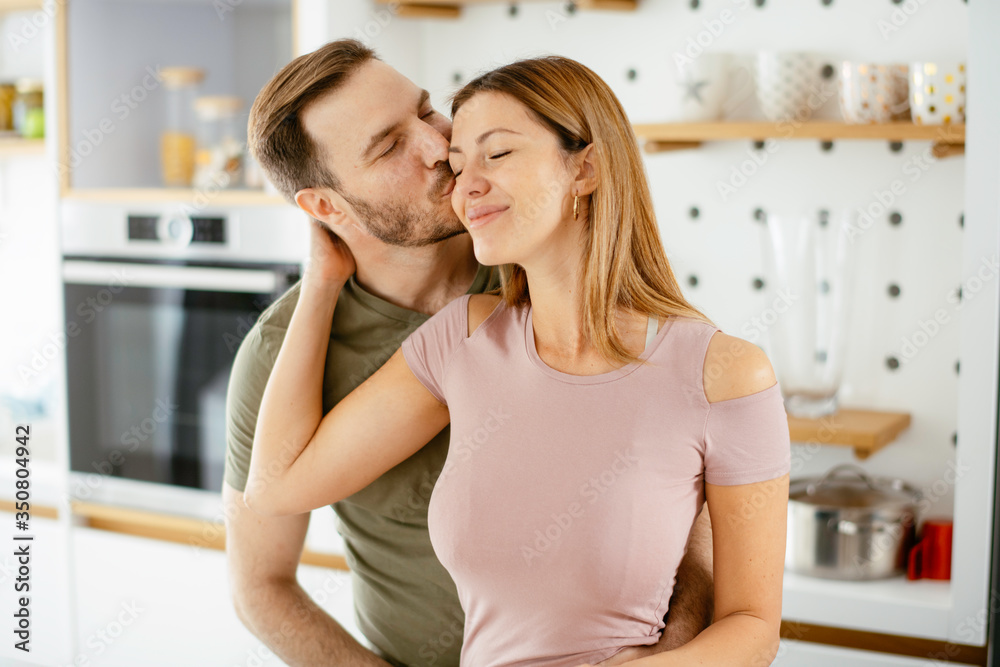 Young couple making breakfast at home. Loving couple drinking coffee in kitchen. Young couple making breakfast at home. Loving couple drinking coffee in kitchen.