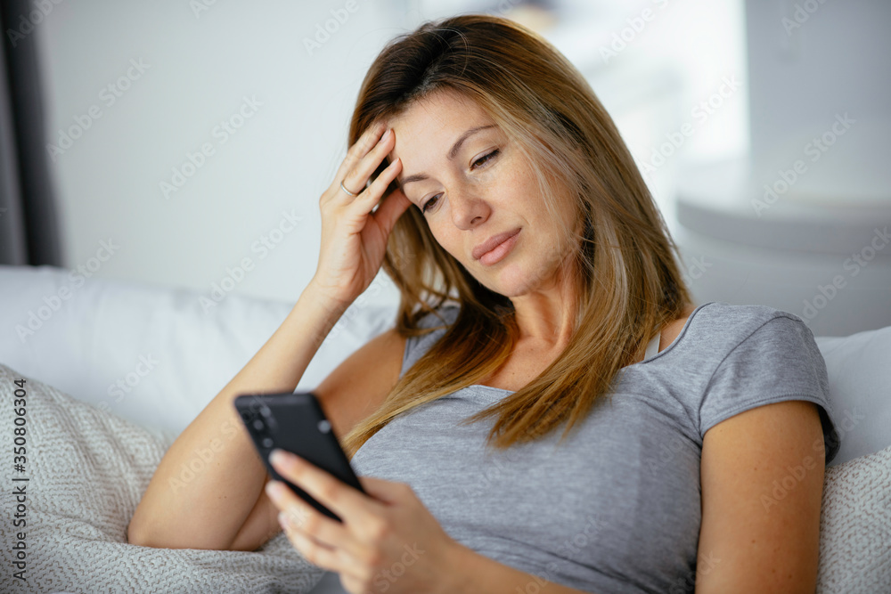 Young beautiful woman using phone in bed. Girl lying on bed. Young beautiful woman using phone in bed. Girl lying on bed.