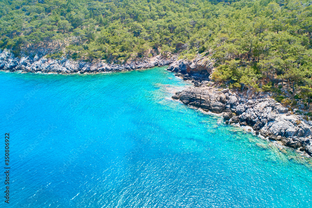 Bright clear sea water and rocky coastline aerial view