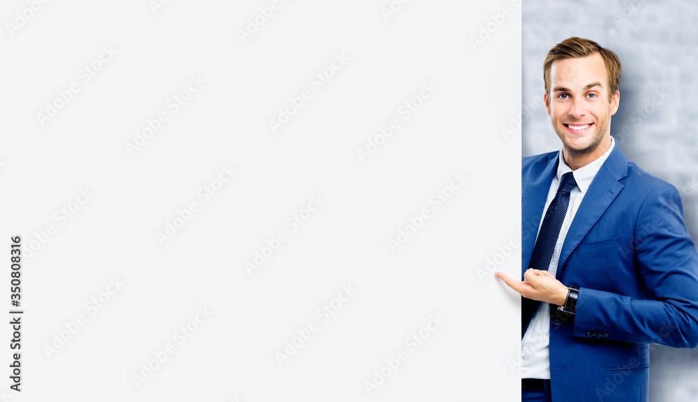 Businessman showing blank signboard, standing over white bricks wall background. Empty copy space area for slogan or some advertising text. Business and education concept. Businessman showing blank signboard, standing over white bricks wall background. Empty copy space area for slogan or some advertising text. Business and education concept.