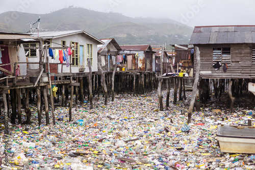 Obraz na płótnie Waters filled with plastics in floating wooden village on the coast of Port Moresby, the capital of Papua New Guinea w salonie