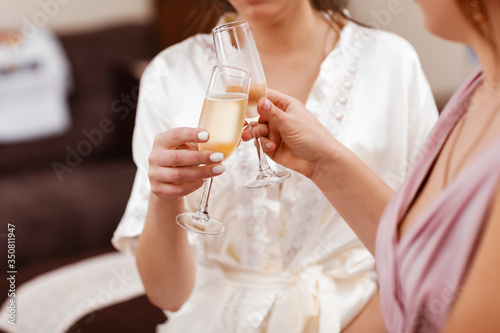 wedding Bridal morning. Bride with bridesmaids drinking champagne in the peignoir.