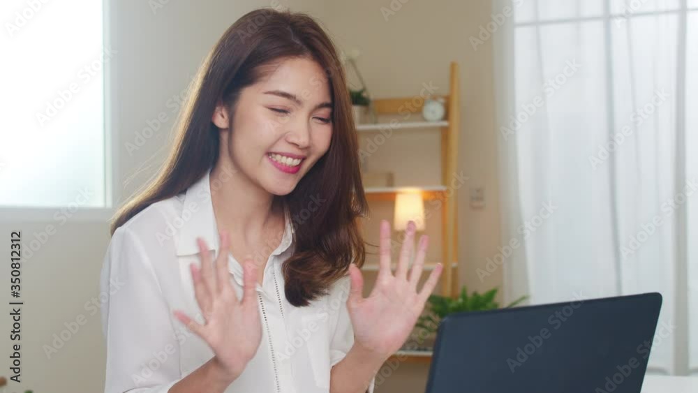 Young Asian business female using laptop video call talking with couple while working from home at living room. Self-isolation, social distancing, quarantine for coronavirus in next normal concept. Young Asian business female using laptop video call talking with couple while working from home at living room. Self-isolation, social distancing, quarantine for coronavirus in next normal concept.