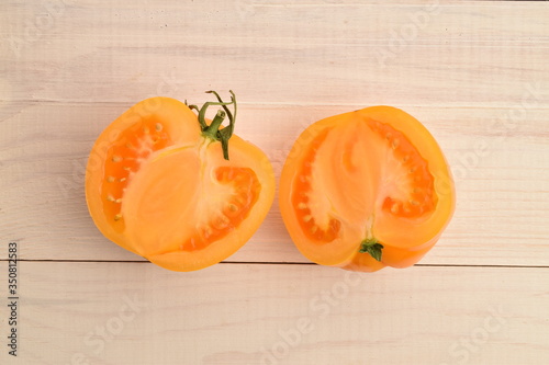 Ripe juicy yellow tomatoes on a painted white table.