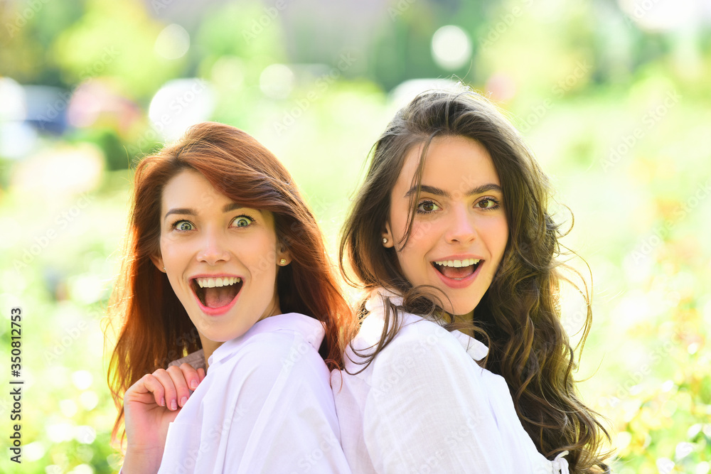Two excited women friends girls posing on green nature background. People lifestyle concept. Two excited women friends girls posing on green nature background. People lifestyle concept.