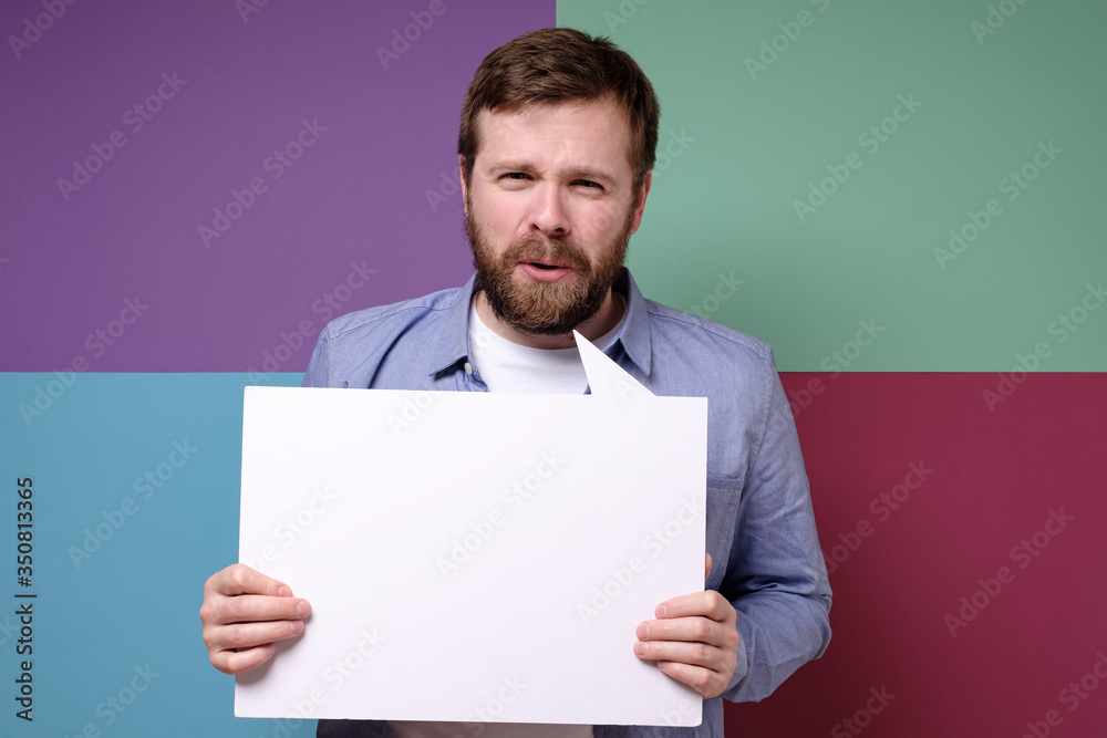 Tricky salesman holds an empty, white board with copy space and says something luring customers. Seasonal discounts. Tricky salesman holds an empty, white board with copy space and says something luring customers. Seasonal discounts.