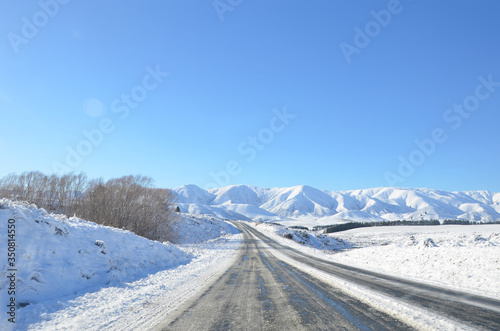 The winter snowy road from Lake Tekapo to Christchurch. The journey pass through several towns and along farmland, then the scenery will start to become mountainous.
