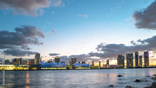 Panorama of Miami city skyline panorama with urban skyscrapers over sea with reflection. Miami waterfront lined with marinas.