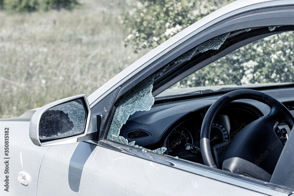 Criminal incident. Hacking a car. Broken driver's side window of car. Thieves smashed window of car with fragments inside, glass was scattered throughout. Crime - broken window and theft belongings