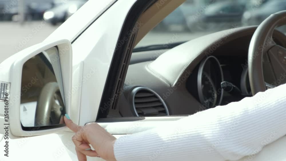 Woman driver adjusting her car rear view mirror. Woman driver adjusting her car rear view mirror.