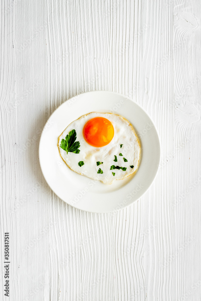 Fried eggs on plate - white wooden kitchen table top-down Fried eggs on plate - white wooden kitchen table top-down