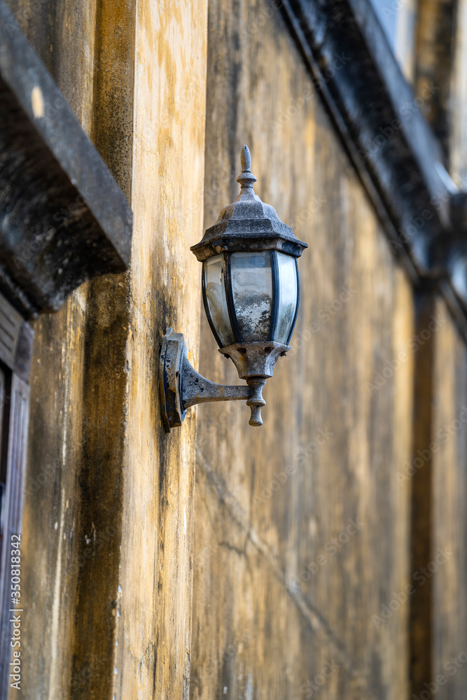 Decorative retro lamp hangs on a yellow wall on the street in Hoi An old town, Vietnam Decorative retro lamp hangs on a yellow wall on the street in Hoi An old town, Vietnam